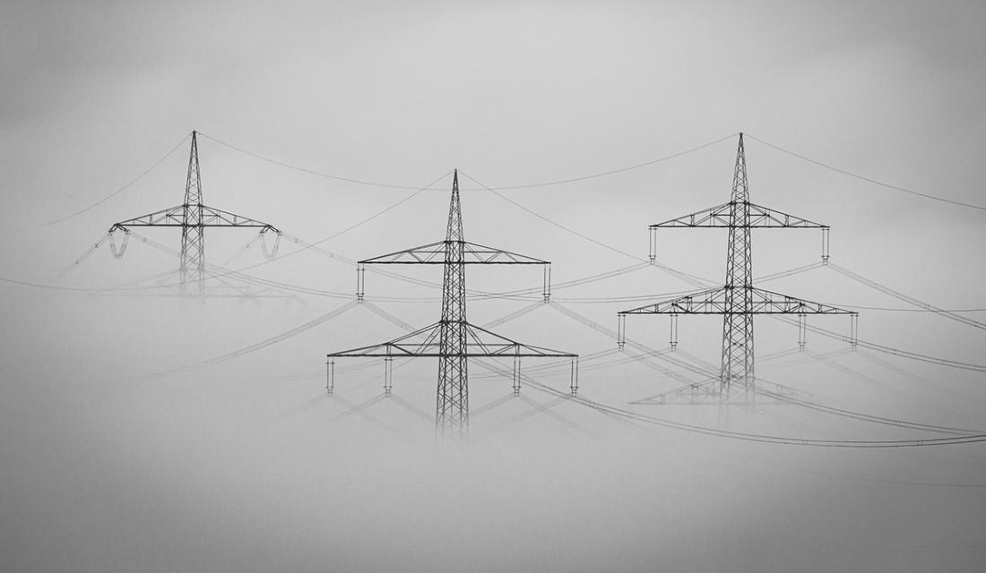 Drei Strommasten im Nebel