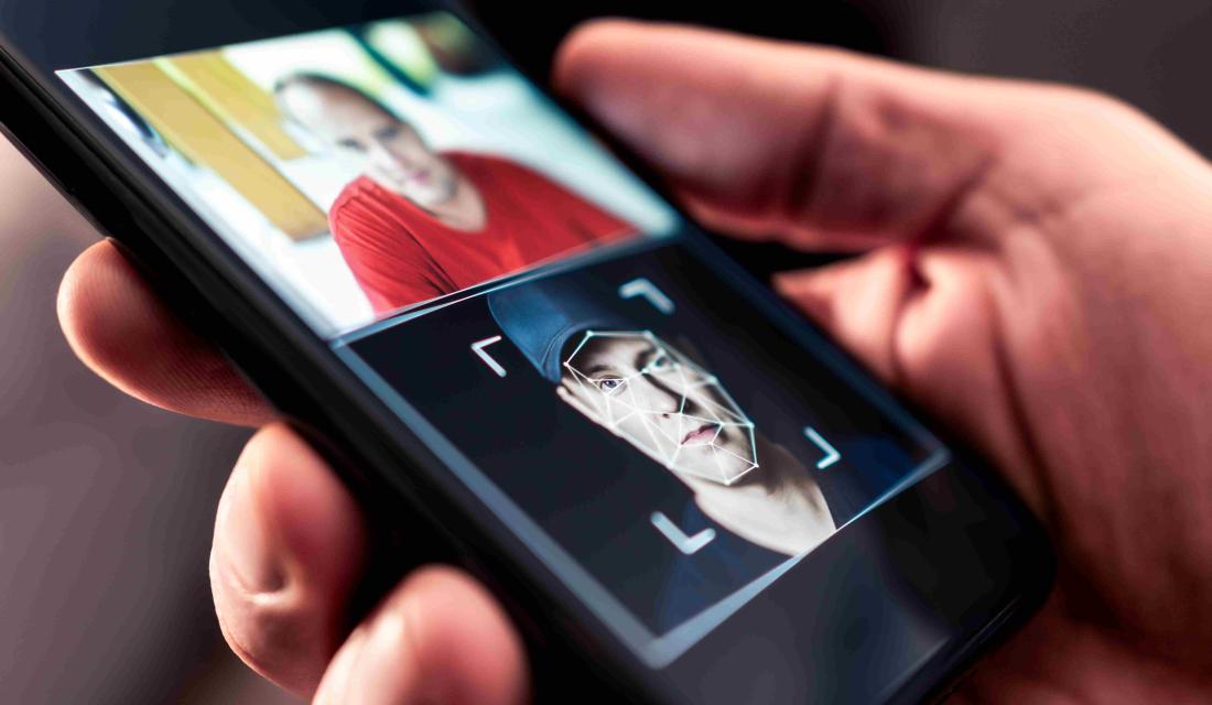  „Smartphone zeigt ein manipuliertes Porträt mit Deepfake-Technologie: Eine Person hält ein Handy, auf dessen Bildschirm ein Gesicht mithilfe künstlicher Intelligenz verändert wurde. Symbolbild für Deepfake, Gesichtstausch, Identitätsdiebstahl und KI-gestützte Bildbearbeitung.