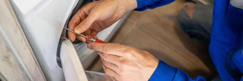 Ein Installateur repariert eine Waschmaschine 