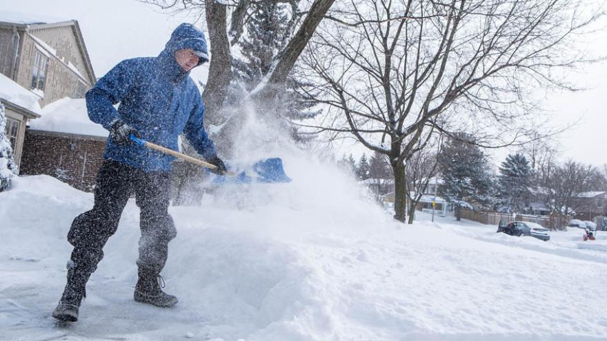 Mann beim Schnee schippen