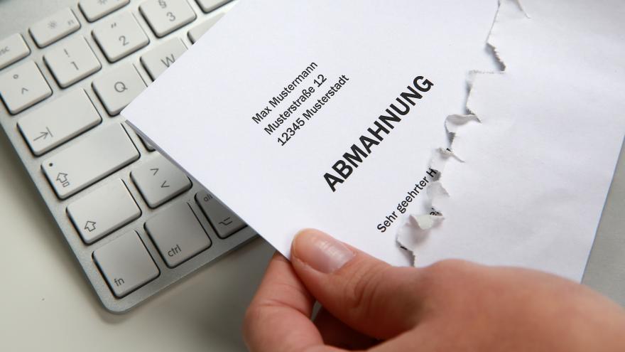 Eine Computertastatur und ein Mahnschreiben. 