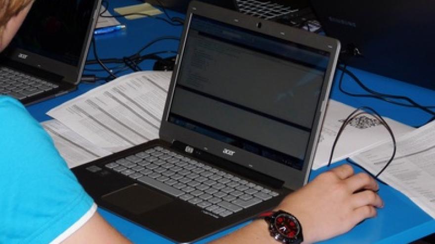 Eine Frau sitzt vor ihrem Laptop und checkt ihre E-Mails.