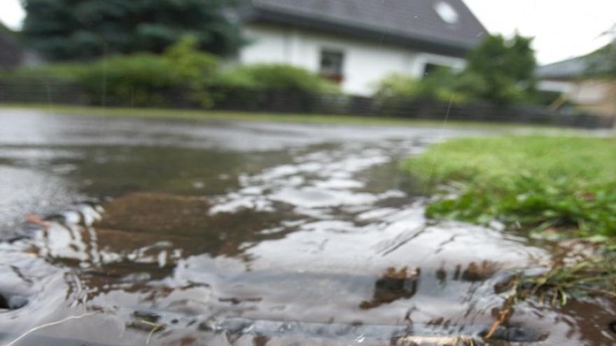 Wasser fließt in einen Gulli.