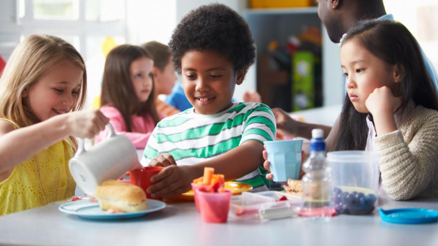 Schulkinder beim Mittagessen im Speisesaal.