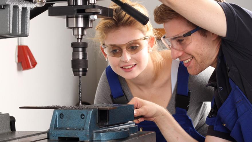 Zwei junge Menschen mit Schutzbrille an einer Drehbank