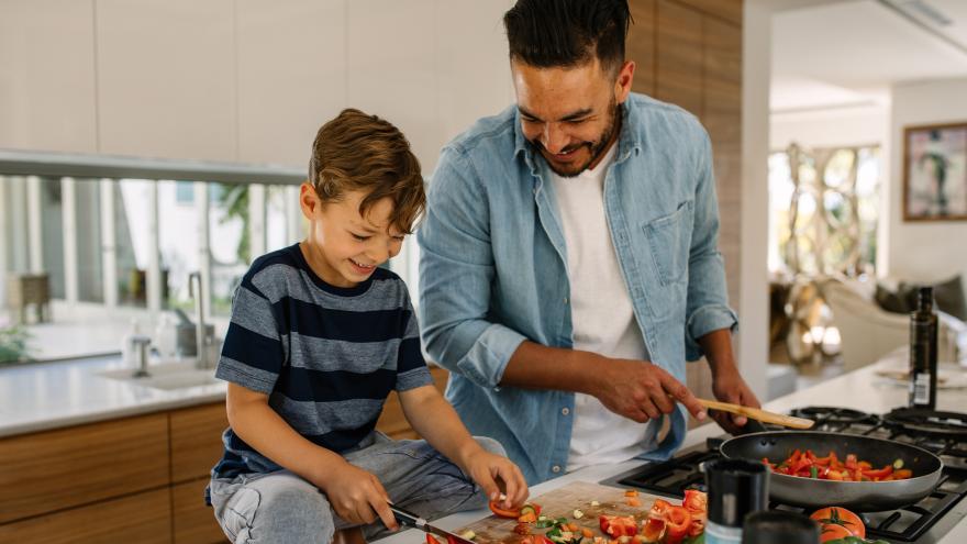 Ein Mann und ein kleiner Junge stehen in der Küche und bereiten Essen zu
