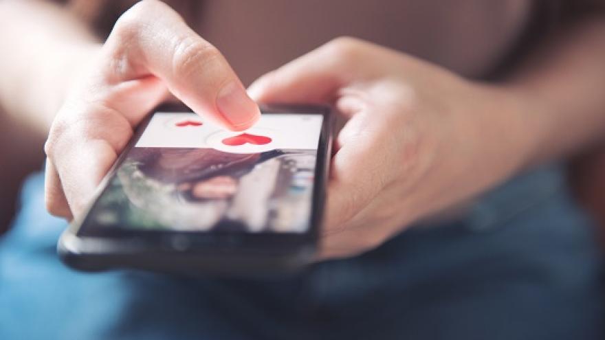 Eine Frau nutzt per Smartphone eine Singlebörse im Internet.