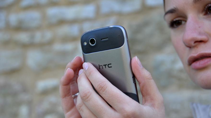 Eine junge Frau schaut besorgt auf ihr Smartphone.