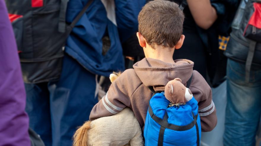 Kind mit Rücksack und Stofftier flüchtet mit anderen aus der Ukraine.