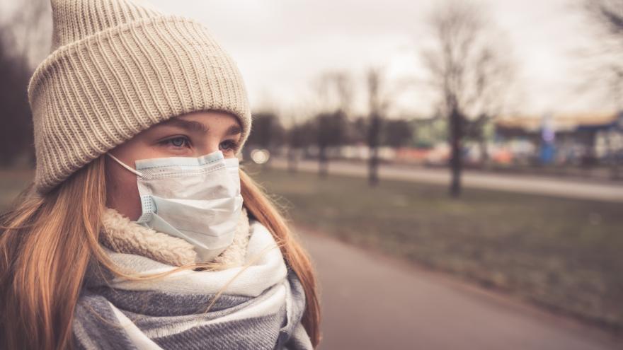 Eine junge Frau trägt einen Mundschutz