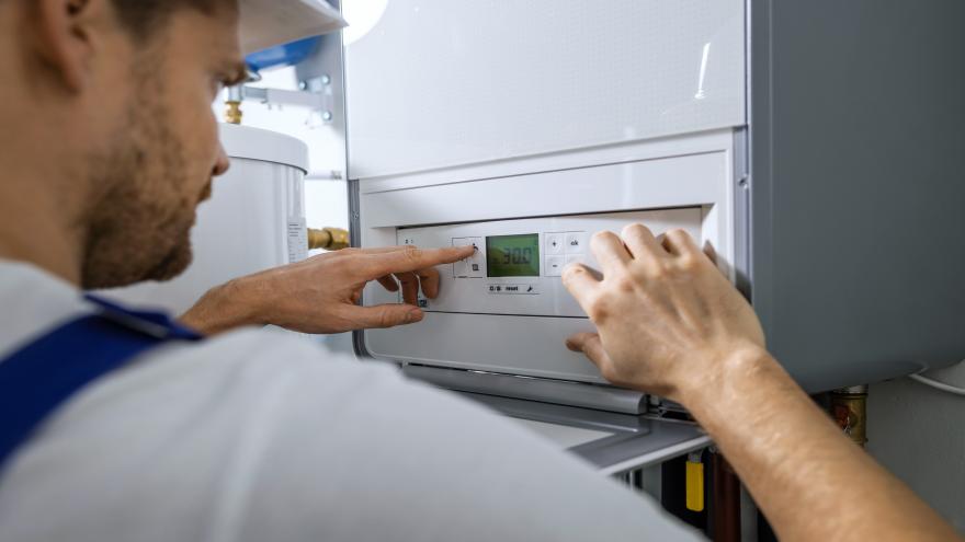 Ein Handwerker installiert einen Gasboiler.