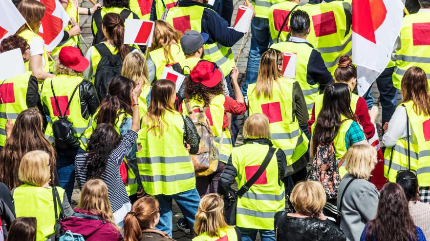 Streikende Menschen in Gewerkschaftsjacken und mit Fahnen