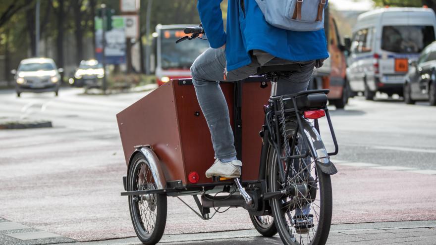 Ein Mann fährt auf einem Lastenfahrrad