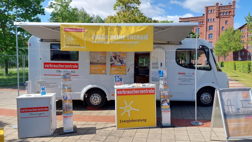 Zu sehen ist das Infomobil der Verbraucherzentrale Thüringen, ein weißes Wohnmobil mit Infotheke und Flyerständern.