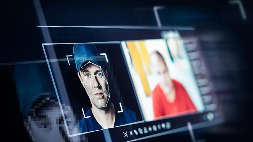 Ein Computerbildschirm zeigt das Gesicht einer Person, das gerade mit Hilfe künstlicher Intelligenz bearbeitet wird. 