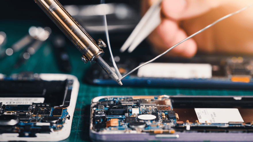 Ein Smartphone liegt geöffnet auf einem Tisch und wird repariert 