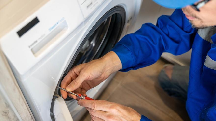 Ein Installateur repariert eine Waschmaschine 