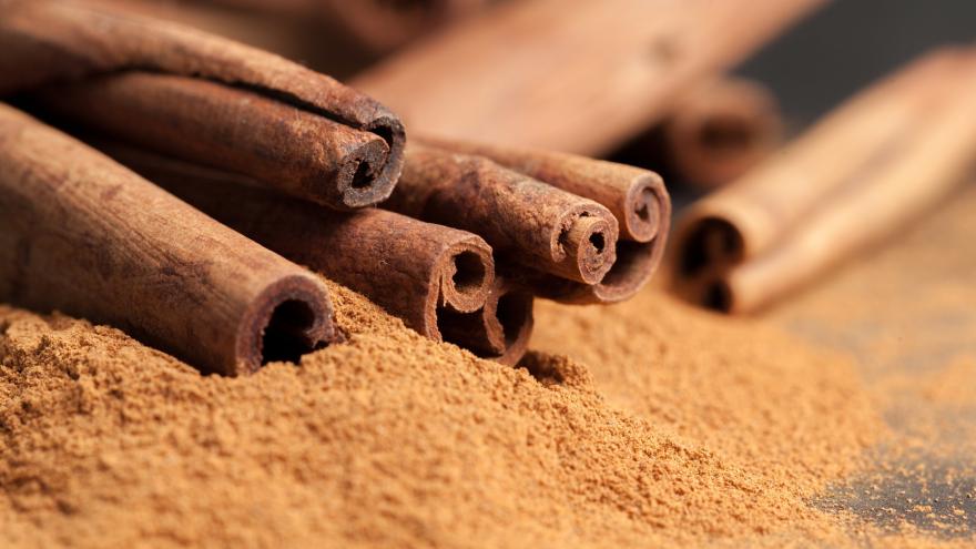 Cassia-Zimtrollen und gemahlener Zimt liegen auf einem Tisch.