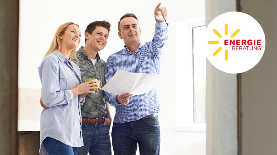 Drei Personen stehen in einem hellen Raum: Ein Mann hält einen Bauplan in der Hand und zeigt nach oben, daneben lächeln ein Mann und eine Frau – rechts ist das Logo „Energieberatung“ zu sehen.