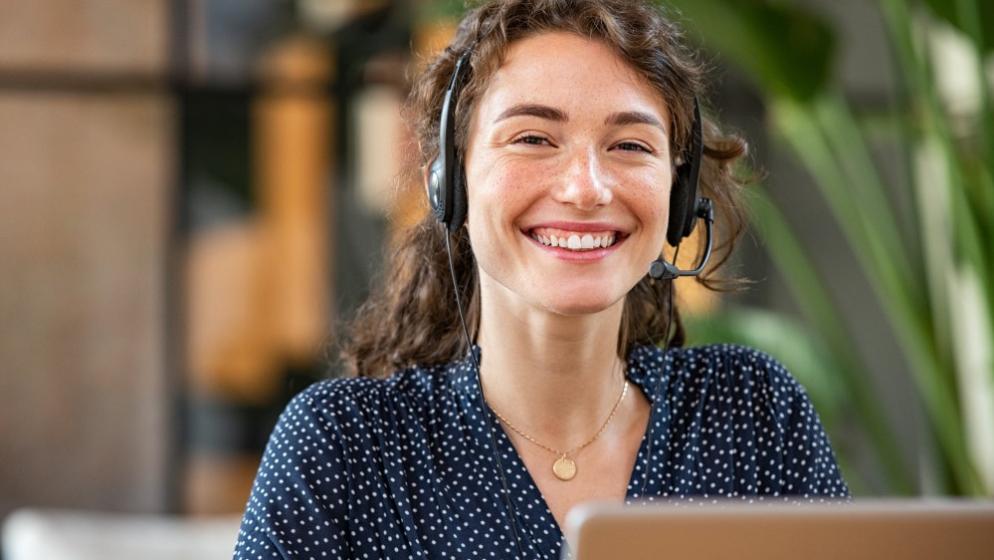 Eine Frau mit Headset am Computer 