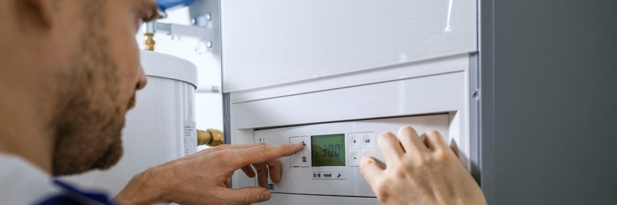 Ein Handwerker installiert einen Gasboiler.