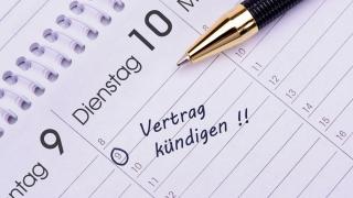 Auf einem Kalender liegt ein Kugelschreiber, an einem Tag ist die Notiz "Vertrag kündigen" eingetragen.
