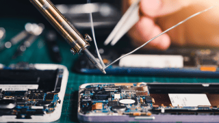 Ein Smartphone liegt geöffnet auf einem Tisch und wird repariert 