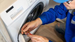 Ein Installateur repariert eine Waschmaschine 